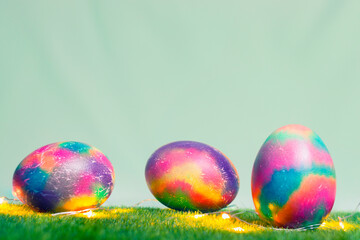 Multicolored Easter eggs backlit on the grass, Easter card. Copy space.