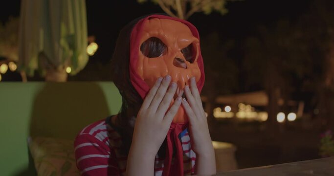 young child play with halloween pumpkin mask at darkness