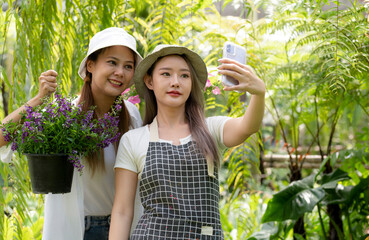 Fototapeta premium Asian women chat online to sell flower plants.