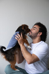 man in his bedroom playing with his dog, man holding his dog in his lap