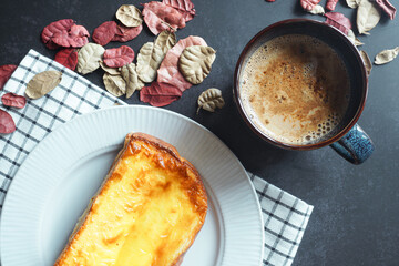 Hot latte coffee and cheese bread on the dark table for a light breakfast with dry leaves for winter theme - 540281238