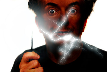 man with burnt face and a cable in hand, humorous concept for danger of manipulating electricity 