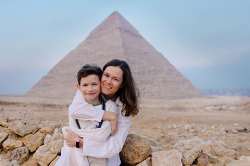 Mother and child together in front of the pyramids in Cairo. Tourist trip to Egypt. Excursion to...