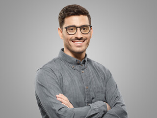 Handsome smiling business guy wearing gray shirt and glasses, feeling confident with crossed arms