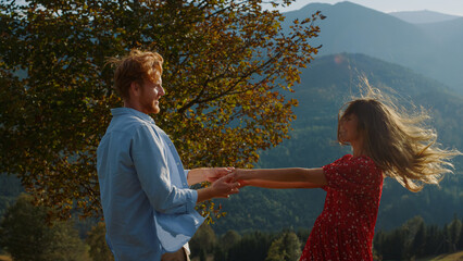 Dancing lovers embrace outdoors. Cheerful family enjoy hug together in mountains