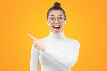Excited girl surprised with beneficial commercial offer or sales, pointing with finger to the left