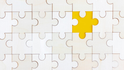 Fototapeta premium White Wood jigsaw puzzle on yellow background with copy space. Business strategy teamwork or problem solving concept.