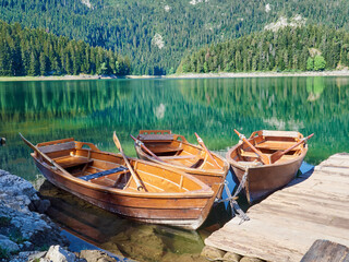 Idyllic tranquil scene of wooden rowboats in Black Lake,  Crno jezero. National Park, Zabljak,...
