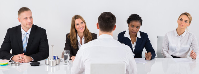 Businesspeople Interviewing Man