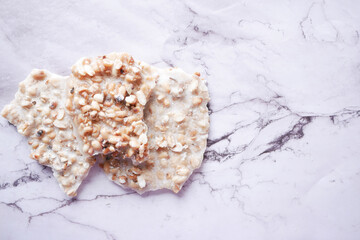 pea nuts sweet bar on white tiles background 