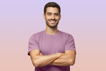 Fototapeta premium Indoor portrait of european caucasian man on purple background in t-shirt with crossed arms