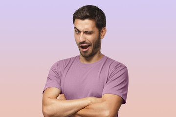 Studio shot of young man winking while flirting on purple background
