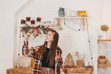 Happy girl with long hair in the Christmas kitchen takes a selfie