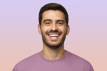 Close up horizontal shot of handsome smiling unshaven man in purple tshirt laughing out loud