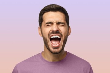 Closeup portrait of screaming with closed eyes crazy young man isolated on purple