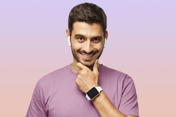 Portrait of handsome man in purple tshirt, showing his stylish modern smart watch with empty screen
