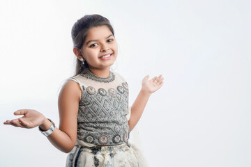 Cute indian little girl in ethnic wear and showing expression over white background