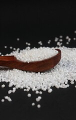 Closeup of Sabudana or Sago Balls in a Wooden Spoon Isolated on Black Background in Vertical Orientation