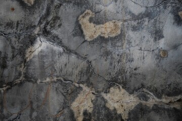 A weathered concrete wall with cracks and peeling paint, showing signs of age and decay.