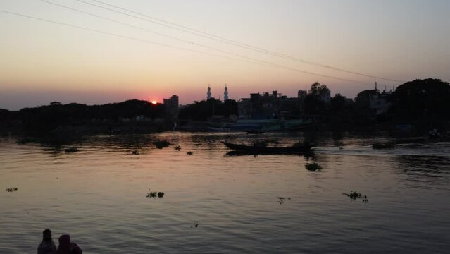 Rowing boats cross the Balu River as dusk falls in Bangladesh
