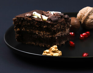 Portion of chocolate dessert cake on plates under dark lighting. Shallow depth of field