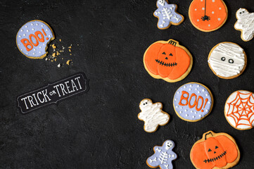 Homemade cookies for Halloween party on a black background.