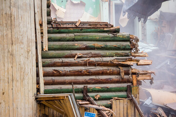 Demolition of an old wooden house with an excavator bucket