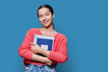 Portrait of teenage high school student on blue color studio background
