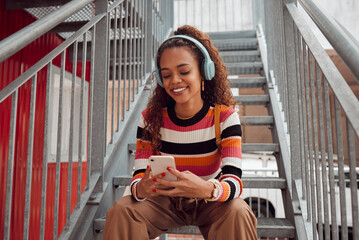 Phone, headphones and black woman on stairs in city streaming music, audio or radio. Gen z,...