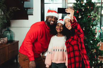 Fototapeta premium A family is celebraing chrismas together. They are taking selfie together.