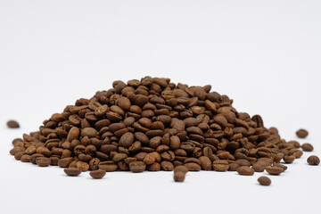 A pile of coffee beans on a white background, place for advertising.