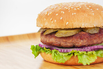 Tasty fast food burger with beef, onion, cucumbers and salad american style