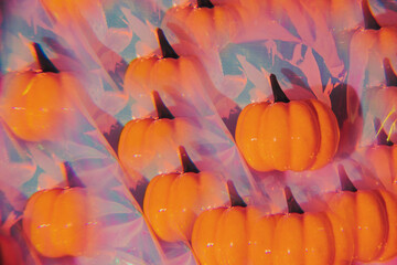 Pumpkin on a holographic background through a prism. Kaleidoscope effect.