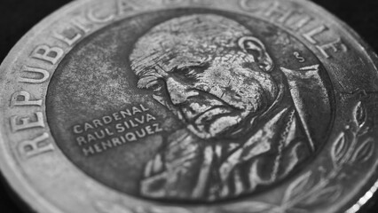 Coin of 500 Chilean pesos lies on a dark surface. Closeup. Peso of Chile. News about economy or money. Loan and credit. Interest and inflation. Black and white wallpaper or background. Macro