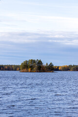Island in a lake inside of a autumn forest inside of Sweden during a sunny fall day. 
