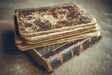 Old vintage hardcover books on a wooden table. Dilapidated old books on the table.