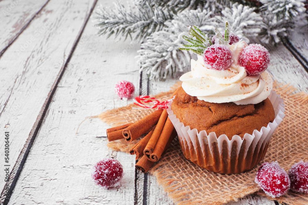 Poster christmas gingerbread cupcake with frosty cranberries. close up on a white wood table background wit