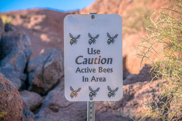Phoenix, Arizona- Close-up of a signage with Use Caution Active Bees In Area at Camelback Mountain