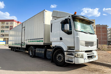 Long white trailer truck parked on the road