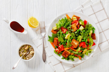 tofu salad with greens and vegetables on plate