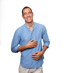 Happy young man laughing against background