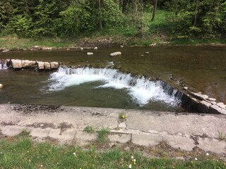 Sunny summer hiking path in the mountains. Rocky Mountain in the summer with trees and forest. Walking in the mountains and forest with blue sky. Summer travel hiking in Europe. 
