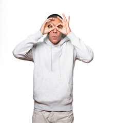 Naklejka premium Happy young man using his hands like a binoculars