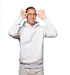 Amazed young man using his hands like a binoculars