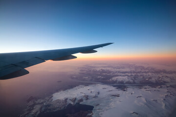 Commercial Aviation Jetplane flying over the ice mountain landscape on the Ocean Coast of...