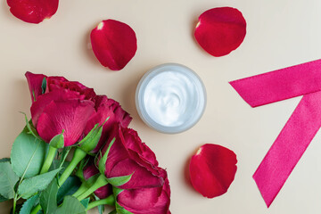 Luxury cosmetic cream ad template. facial cream product jar on beige background surrounded by roses and petals. Top view