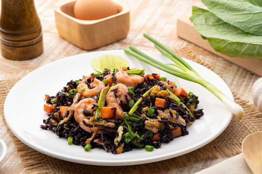Healthy fried riceberry rice (brown jasmine rice) with shrimp and kale carrot in white plate