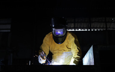 Obraz na płótnie Canvas Industrial technician with Welding PPE weld metal structure in factory, metal welding in factory