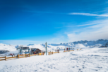 Fototapeta premium People, skiers and snowboarders getting ready to get on a slopes near ski lift on the top of the mountain, Andorra, El Tarter, Pyrenees Mountains