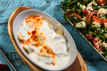 Eid Mubarak Traditional Ramadan Iftar dinner. Assorted tasty food in authentic rustic dishes on wooden blue background. Turkish Bosnian food meat kebab, pita, Sarma, klepe, sogan dolma.